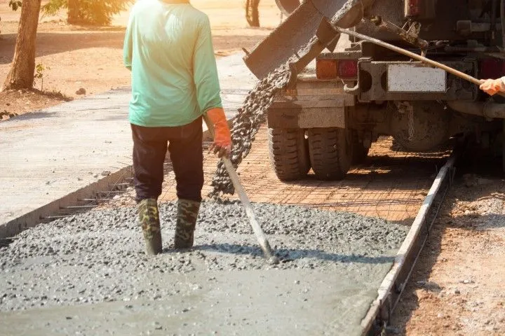 Concrete contractor unloading gravel from truck at job site in Grandview, MO