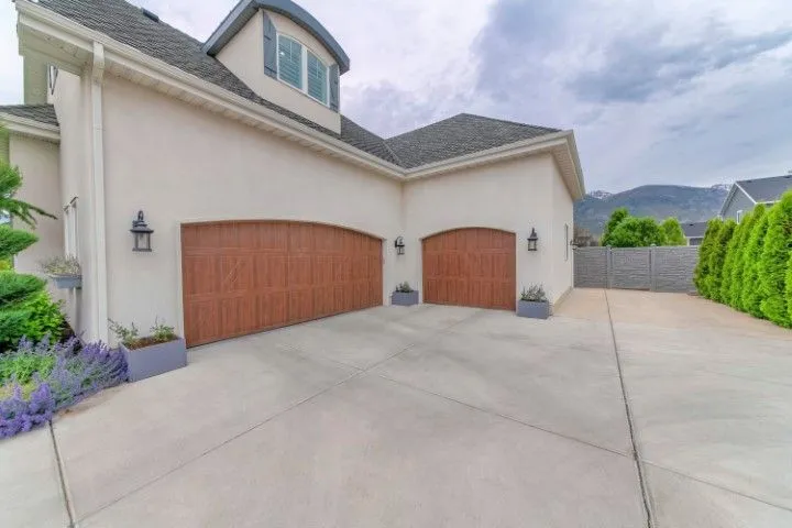 New concrete driveway with two-car garage and landscaped yard in Grandview, MO