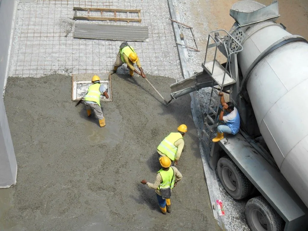 Concrete crew pouring and spreading concrete from cement mixer in Grandview, MO